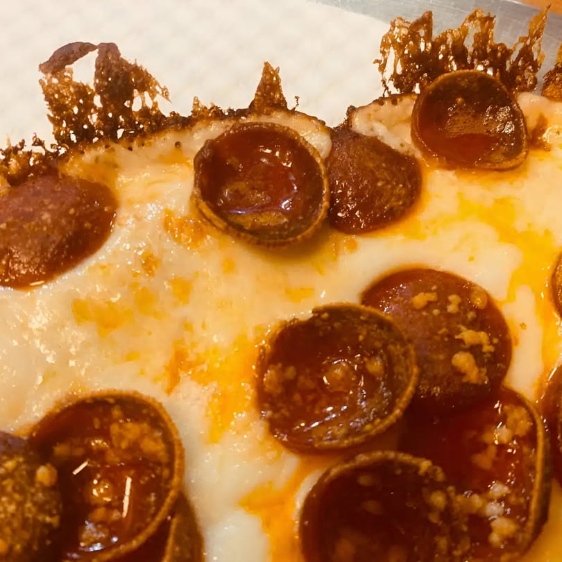 Close-up of a Biaggio Pizzeria pepperoni pizza with melted cheese and crispy edges.