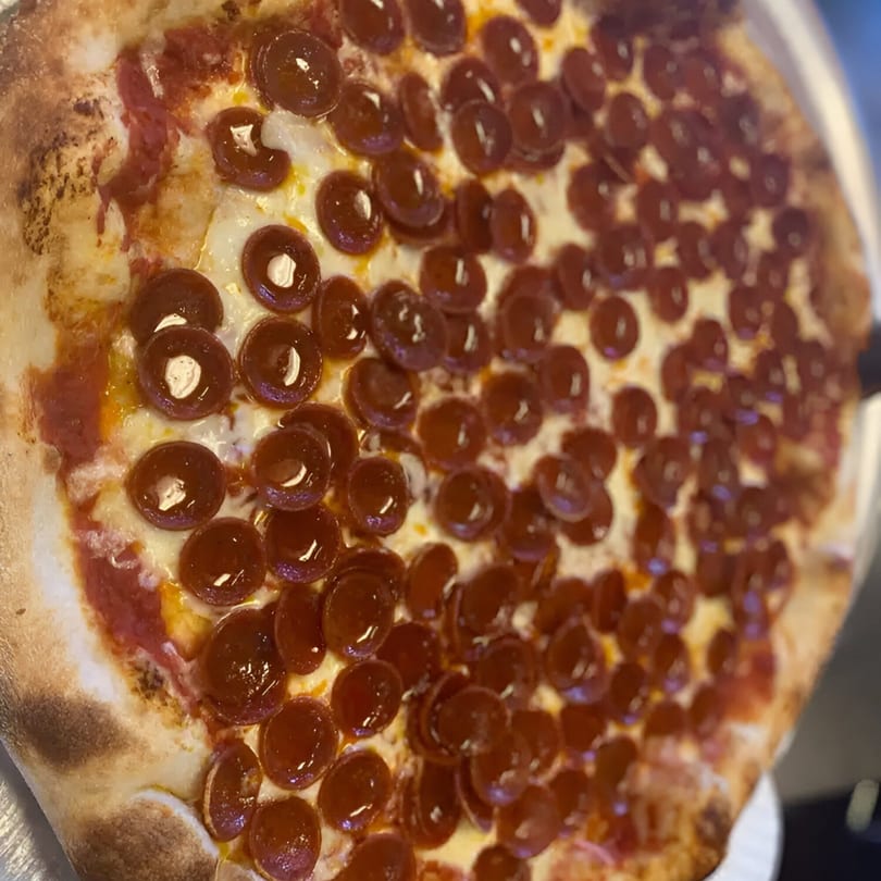Close-up of a Biaggio Pizzeria pepperoni pizza with a crispy crust and melted cheese.