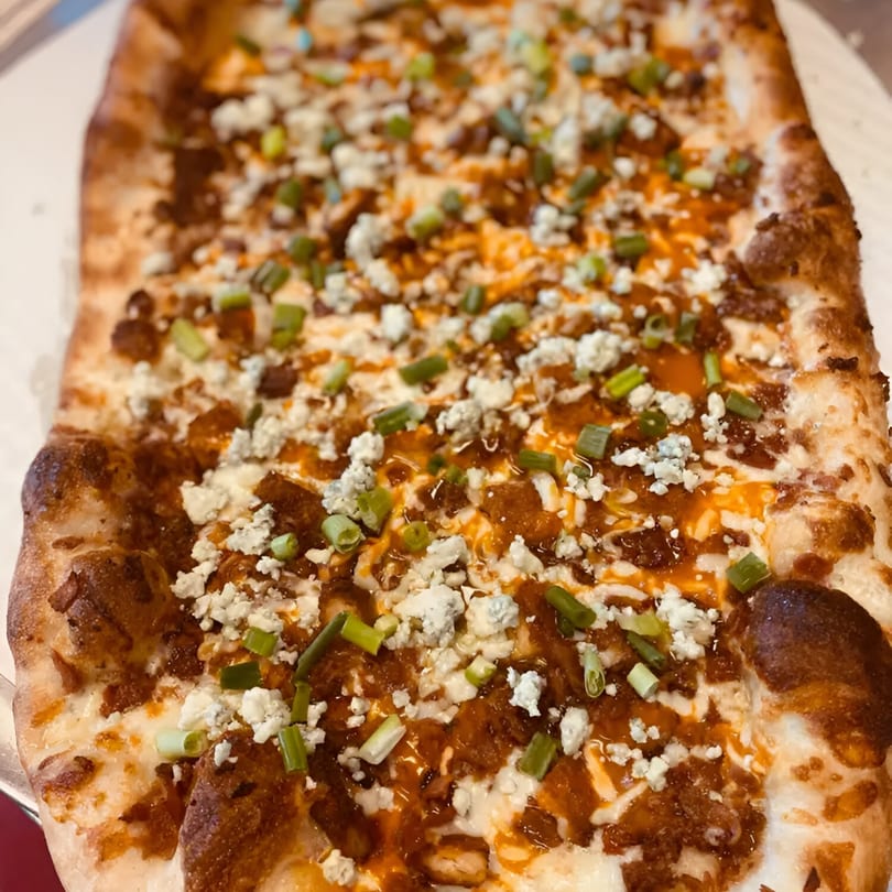 A rectangular Biaggio Pizzeria & Family Restaurant pizza with buffalo chicken, blue cheese, and scallions.