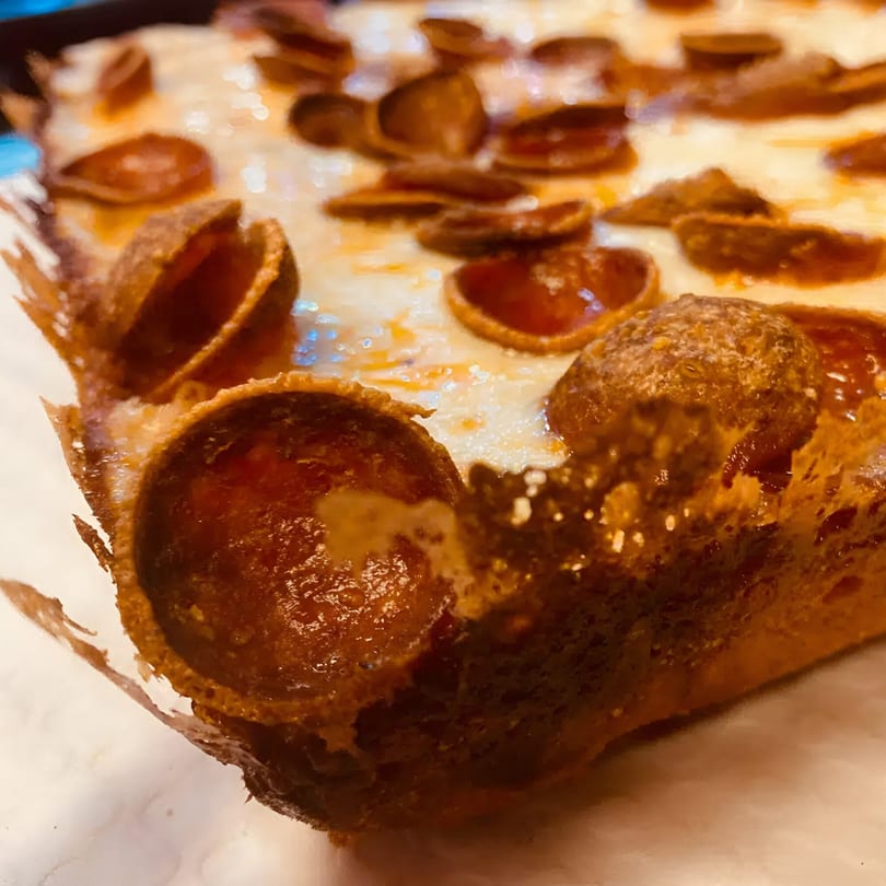 Close-up of a Biaggio Pizzeria pepperoni pizza slice with a crispy, cheesy crust.